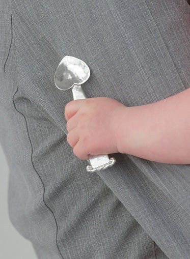Hand holding Vincent spoon showing curved handle design detail