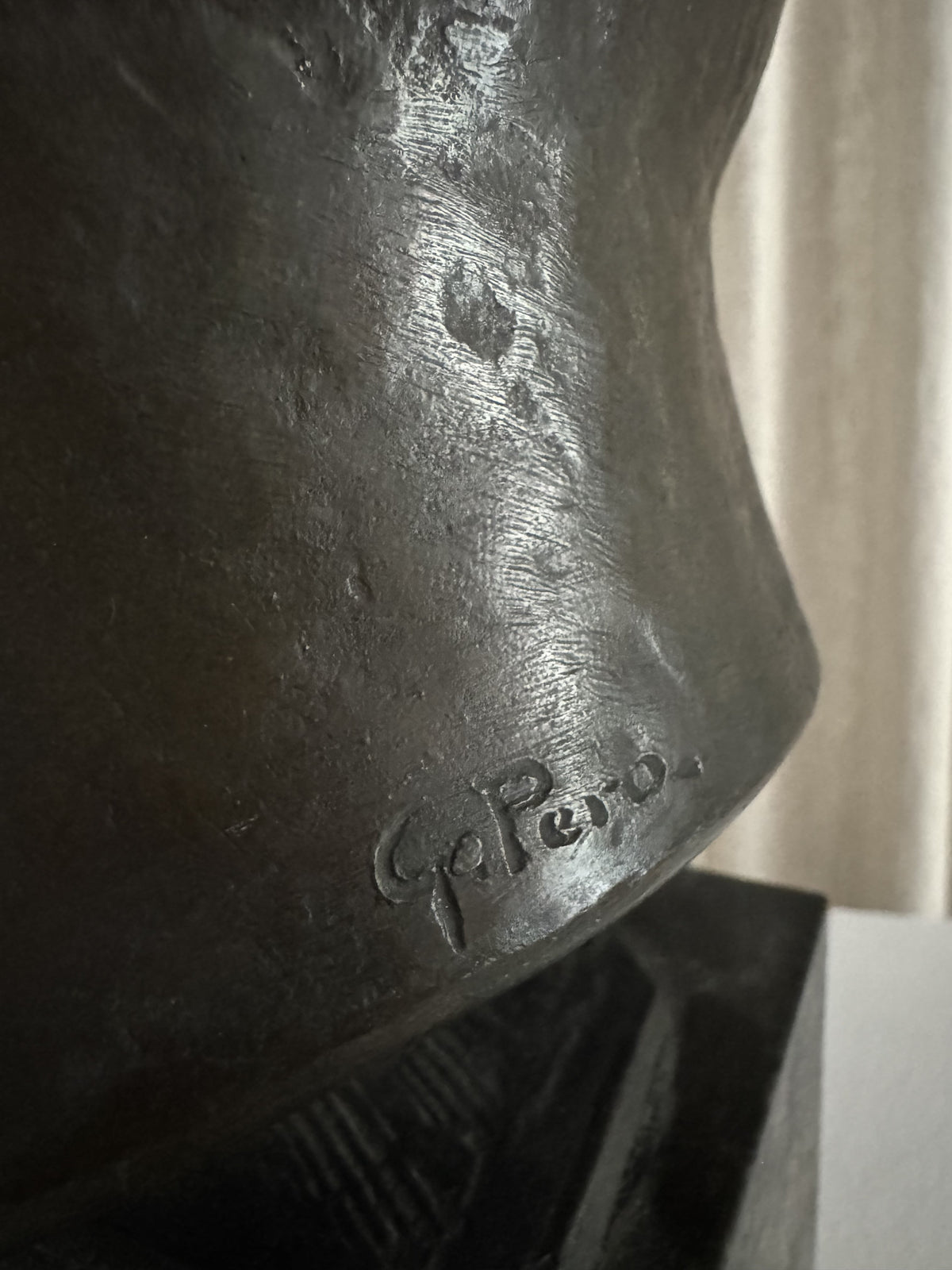 Close-up of the "Testa Virile" Sculpture 1930s by FEBRERO SHOP, showing "G. Pepe" engraved on the bronze base. Rough, unpolished texture and soft right-side lighting emphasize detailed craftsmanship.