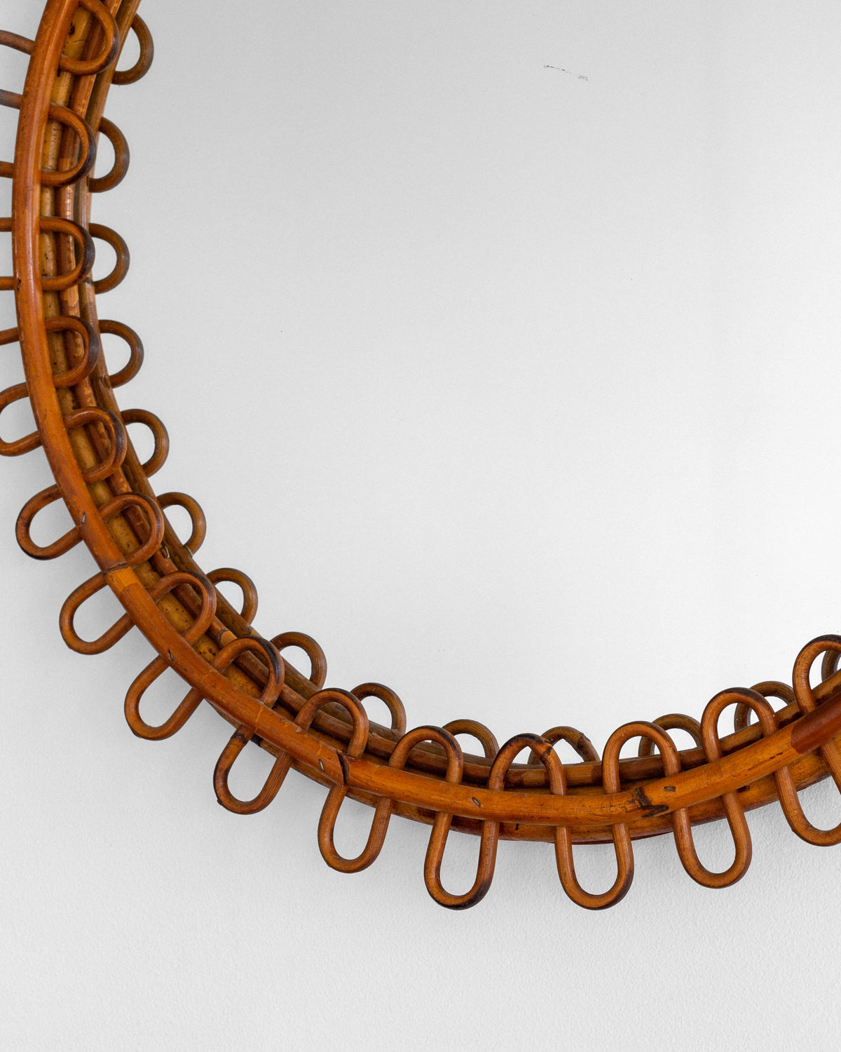 Rattan mirror frame detail showing woven loop border pattern