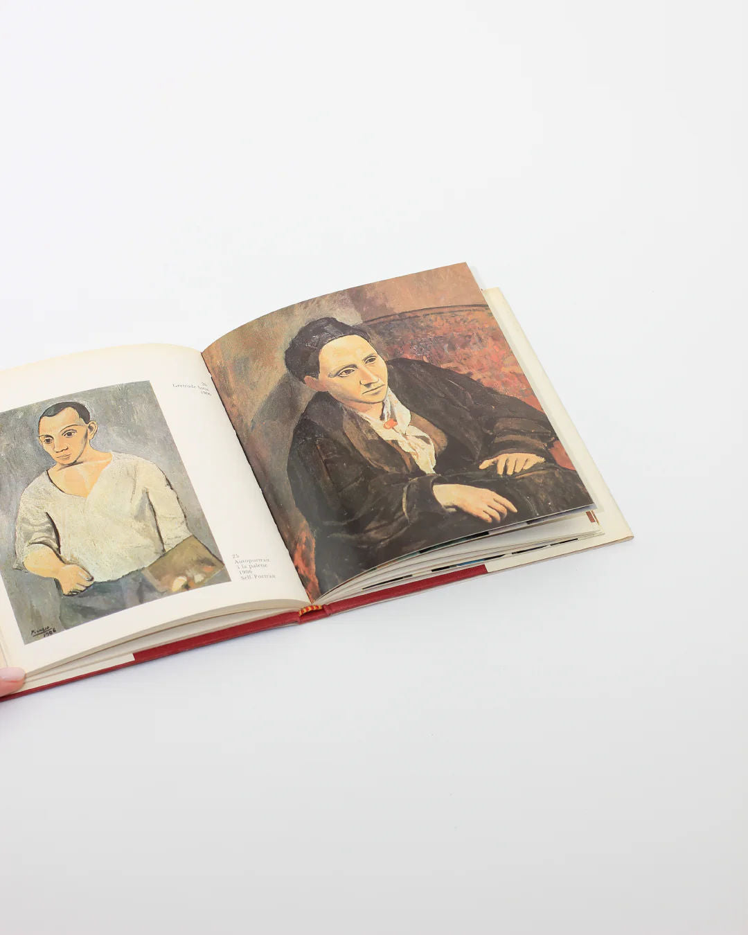 The PICASSO Book from Boga Avante Shop showcases an open display with two portraits: the left shows a person in a white shirt, and the right features one in a dark suit with a white shirt. Set against a light gray background, it captures the innovative spirit of Cubism and modern art.