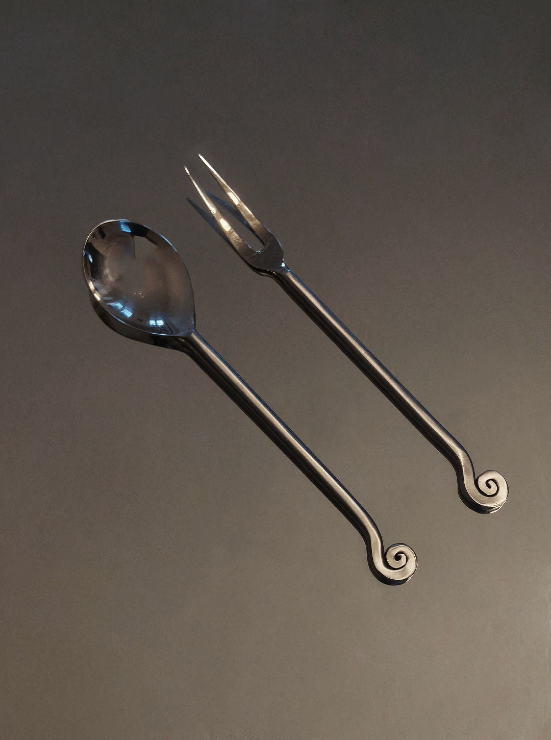 Elegant spiral-handled serving spoon and fork set in polished steel