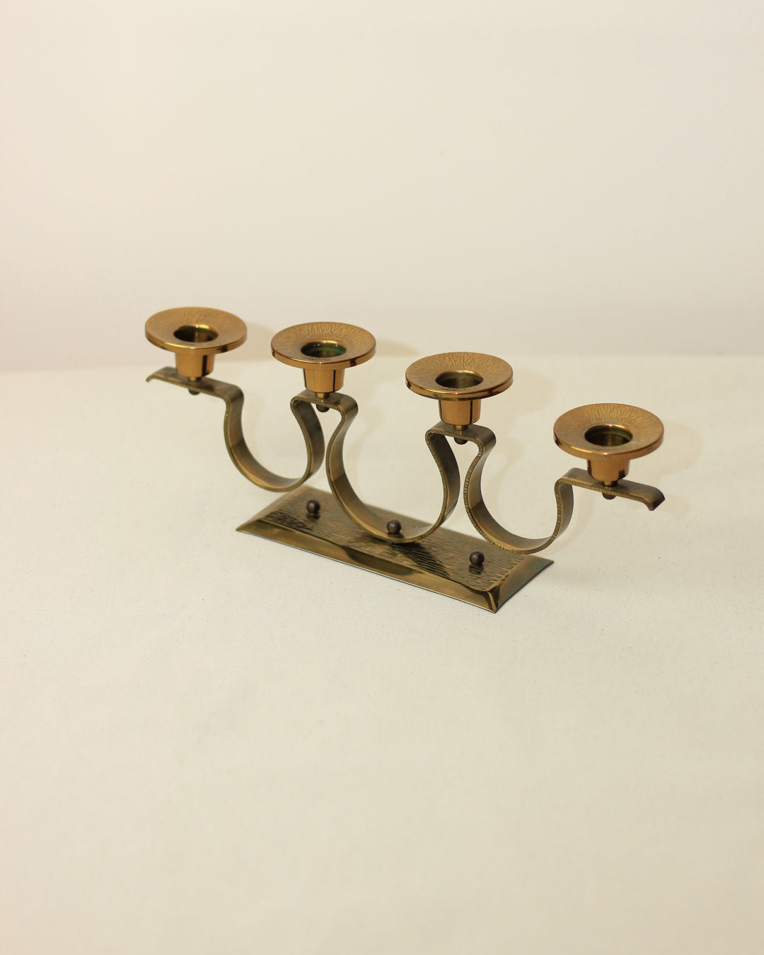 Brass 1960s four-candle holder with curved arms on rectangular base