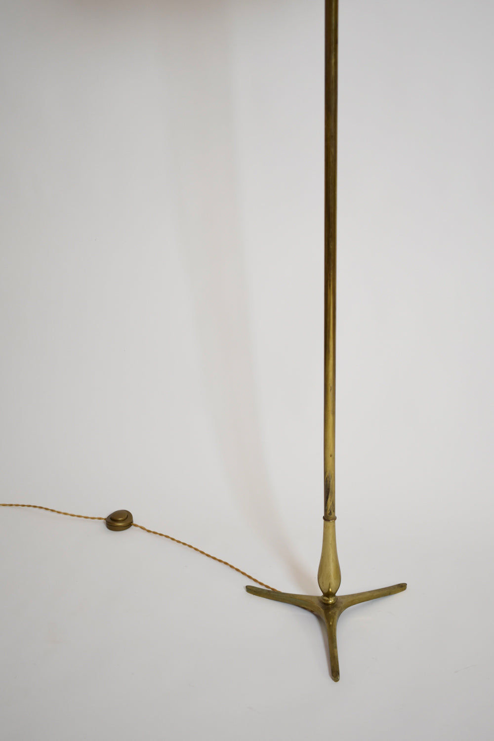 The Tripod Baluster Neoclassical Floor Lamp (1960s) by Barracuda Interiors features a slender brass pole, three-pronged base, and exposed brown cord with a button switch, echoing Riccardo Scarpa style against a plain white background.