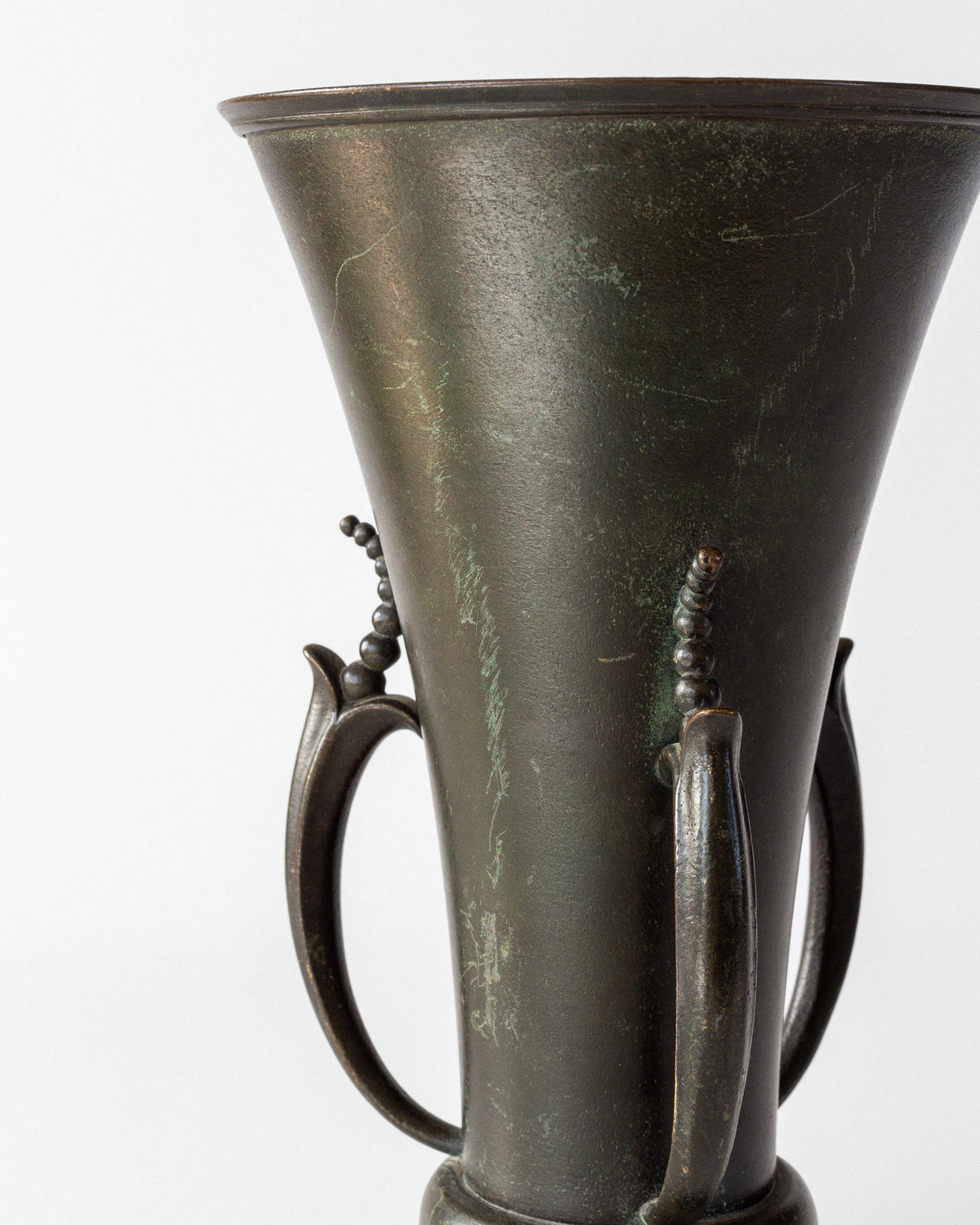 Close-up detail of Grace bronze vase handles with patina finish