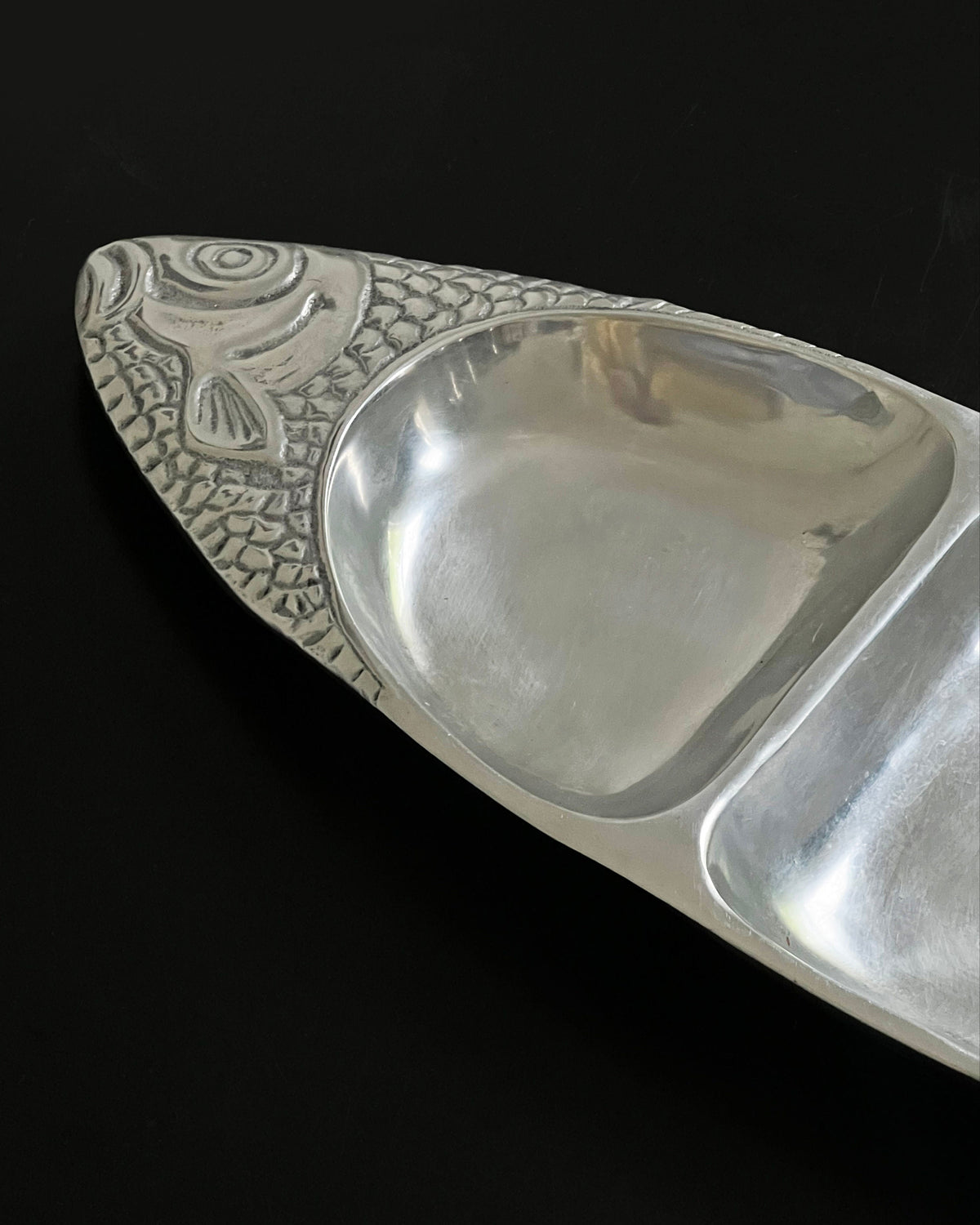 Polished aluminium fish-shaped serving dish detail view
