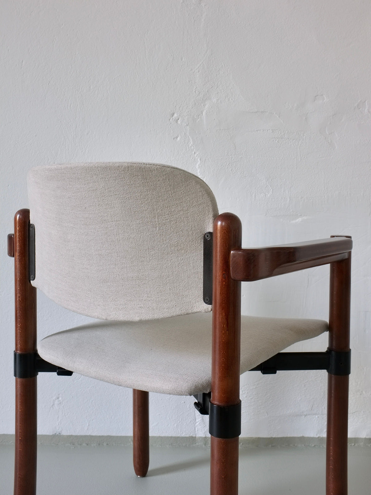 A set of 4 armchairs by Fröscher Sitform, Germany 1970s, from Veter Vintage features a light gray fabric seat and backrest with dark wooden armrests and legs, set against a plain white wall.