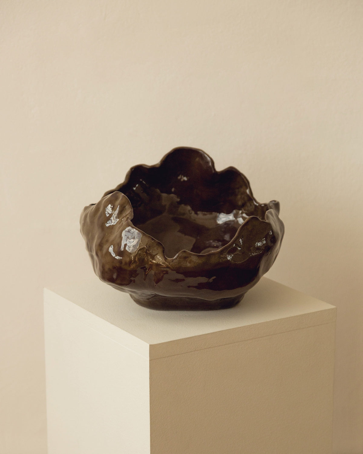 Modica ceramic bowl in glossy brown finish on white pedestal