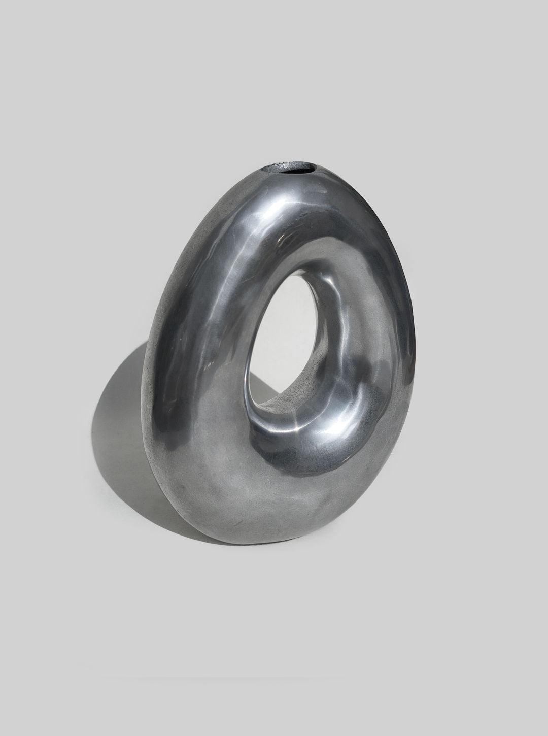 Sculptural grey ceramic vase with flowing curved form and opening