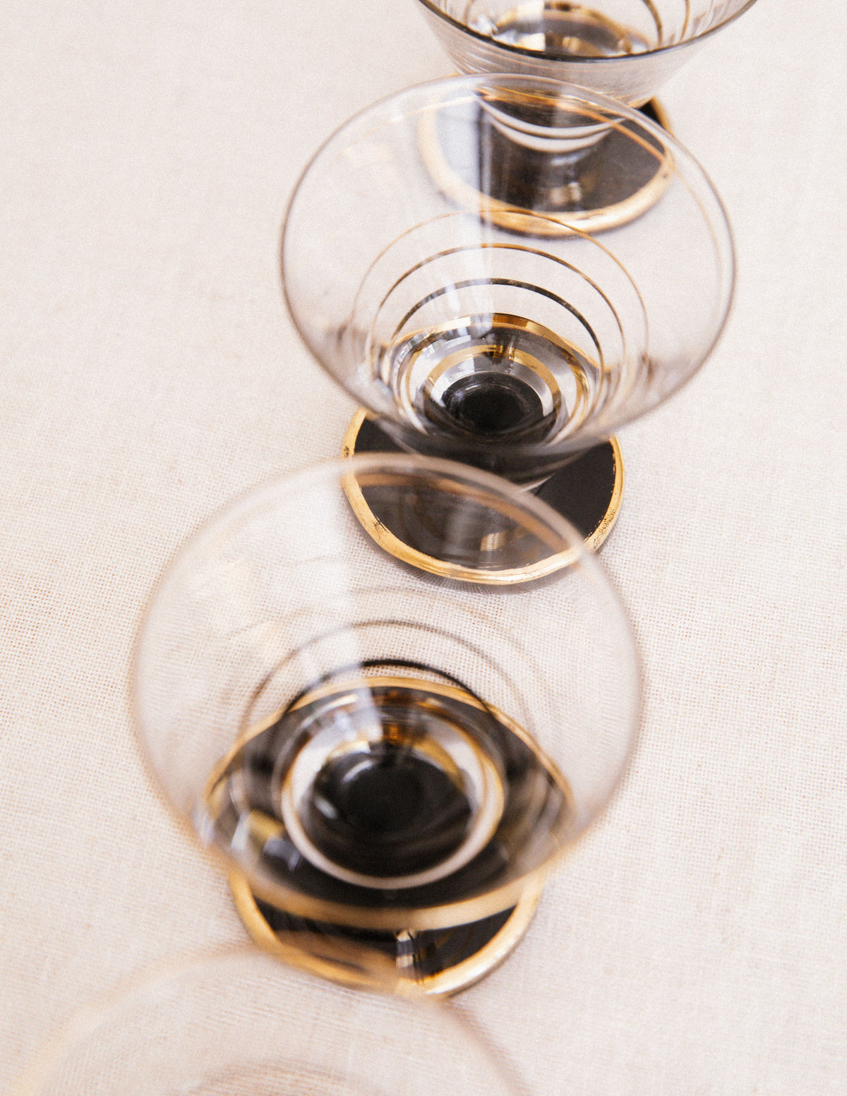 Set of elegant cordial glasses with gold rim detail on linen