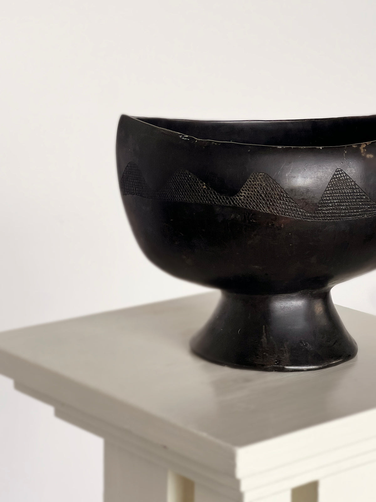 Black ebony carved bowl with mountain motif on pedestal base