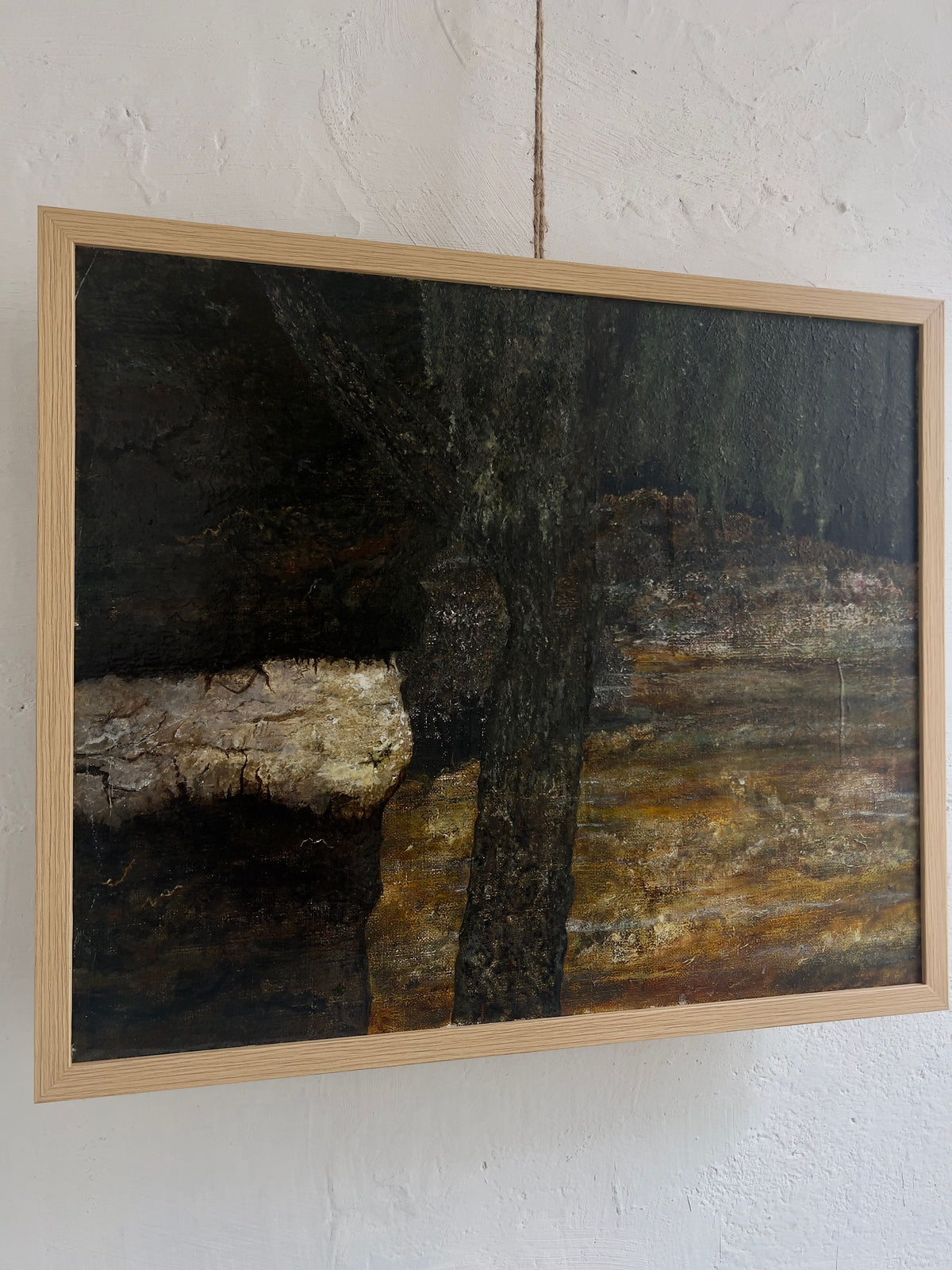 The Veter Vintage "Vintage Landscape Painting, Oil on Canvas" hangs in a light wooden frame on a textured white wall. It depicts a dark abstract tree with a thick trunk against an earthy brown and green background, evoking landscapes reminiscent of the Netherlands.