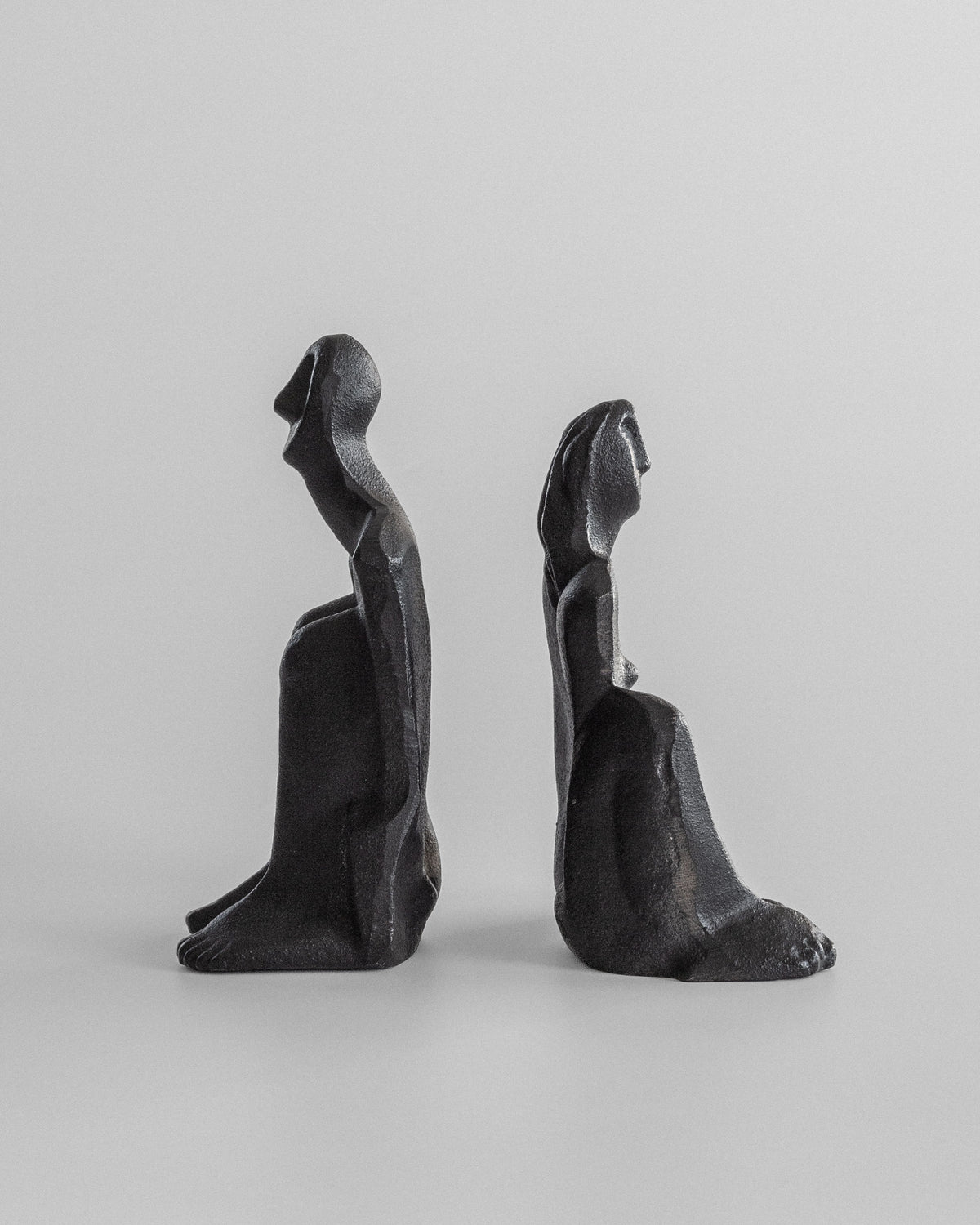 The Male and Female Sculptures by Marita Norin for Spigel are cast-iron figures seated back to back. The minimalist design highlights their curves and contours, making them ideal bookends against a plain backdrop.
