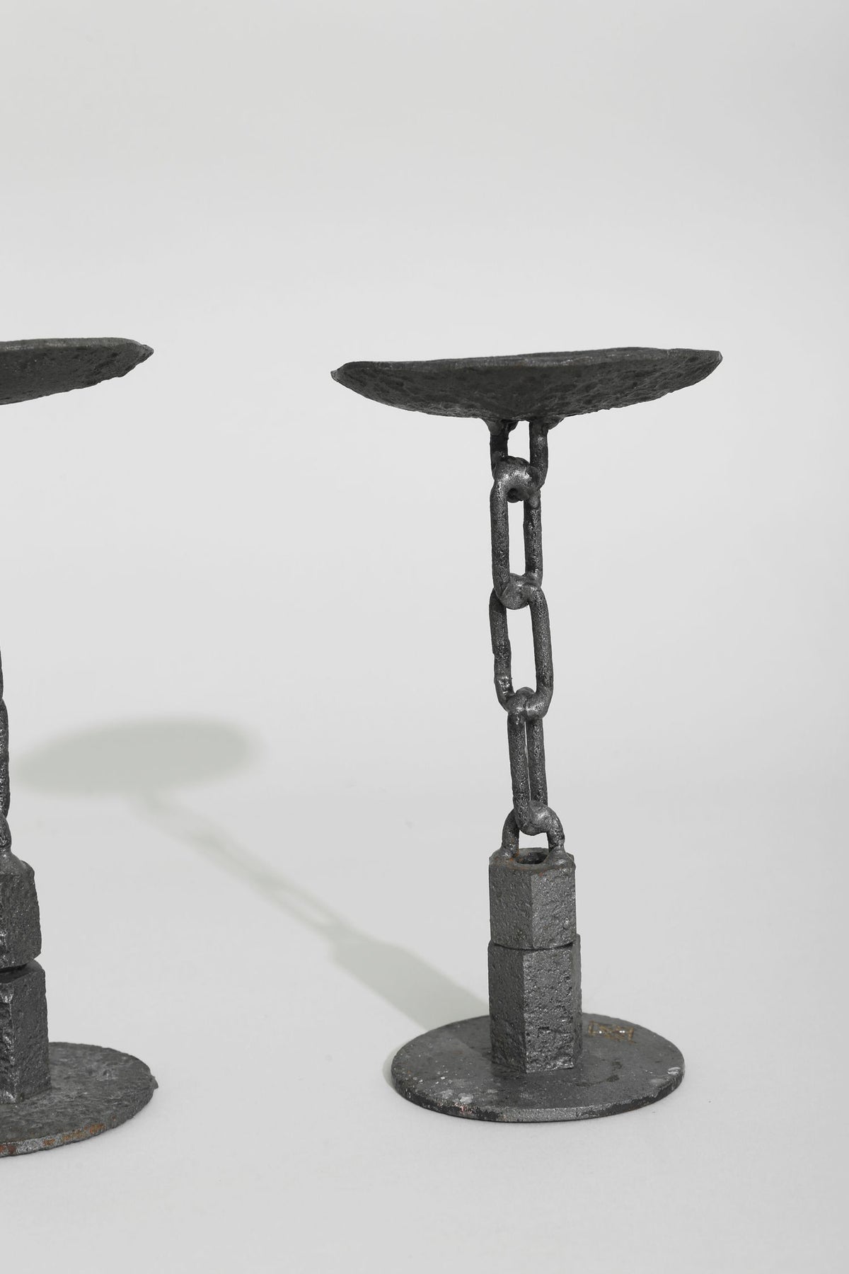 Black iron chain candleholder set with textured oval platforms