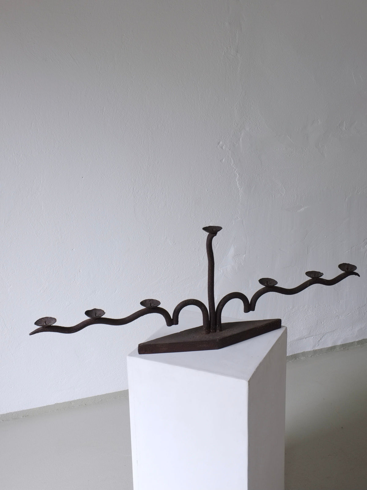 Large brutalist wrought iron candelabra with curved arms displayed