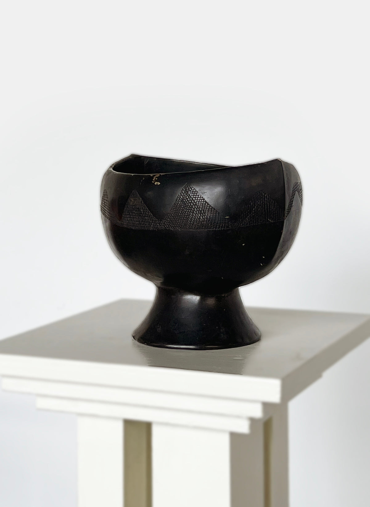Black ebony carved bowl with geometric patterns on pedestal base