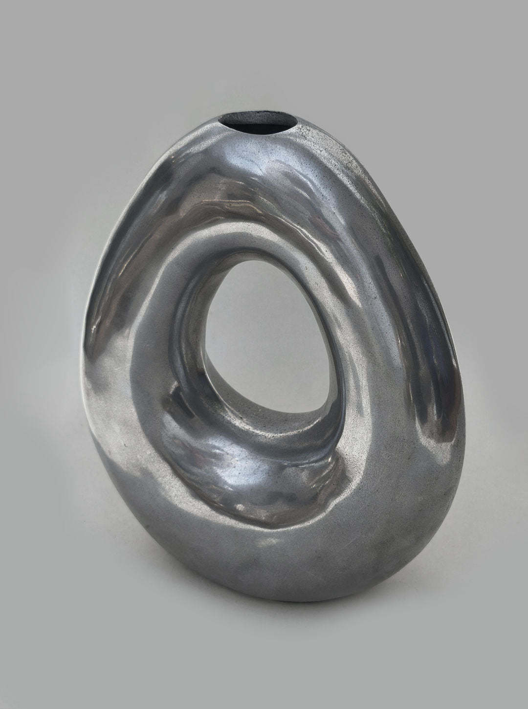 Sculptural metallic circular vase with flowing organic curves