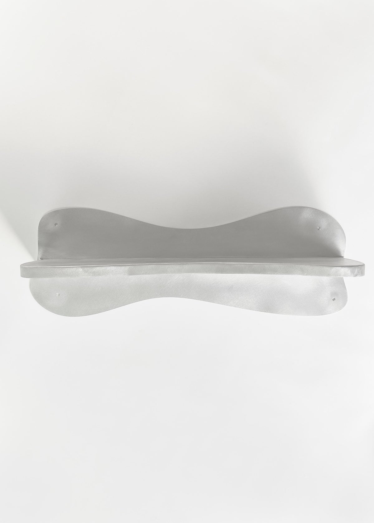 The Big Shelf by Six Dots Design is a white, curved object with smooth lines and a symmetrical shape, mounted against a white background, resembling an abstract sculpture and offering a contemporary artistic appearance.