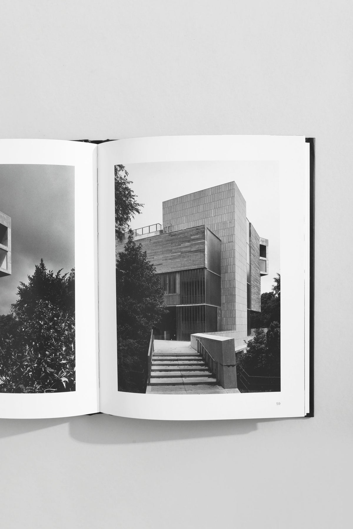 Open architecture book showing modernist concrete building with geometric facades and stone steps