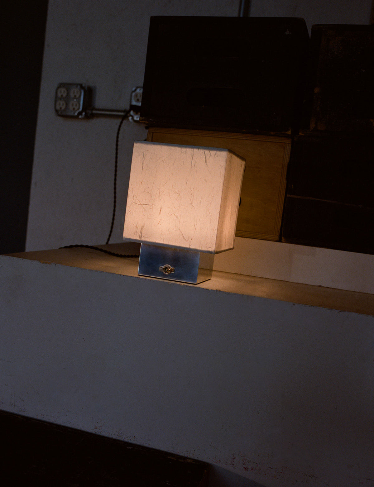 Table lamp with warm fabric shade and blue metal base on white desk