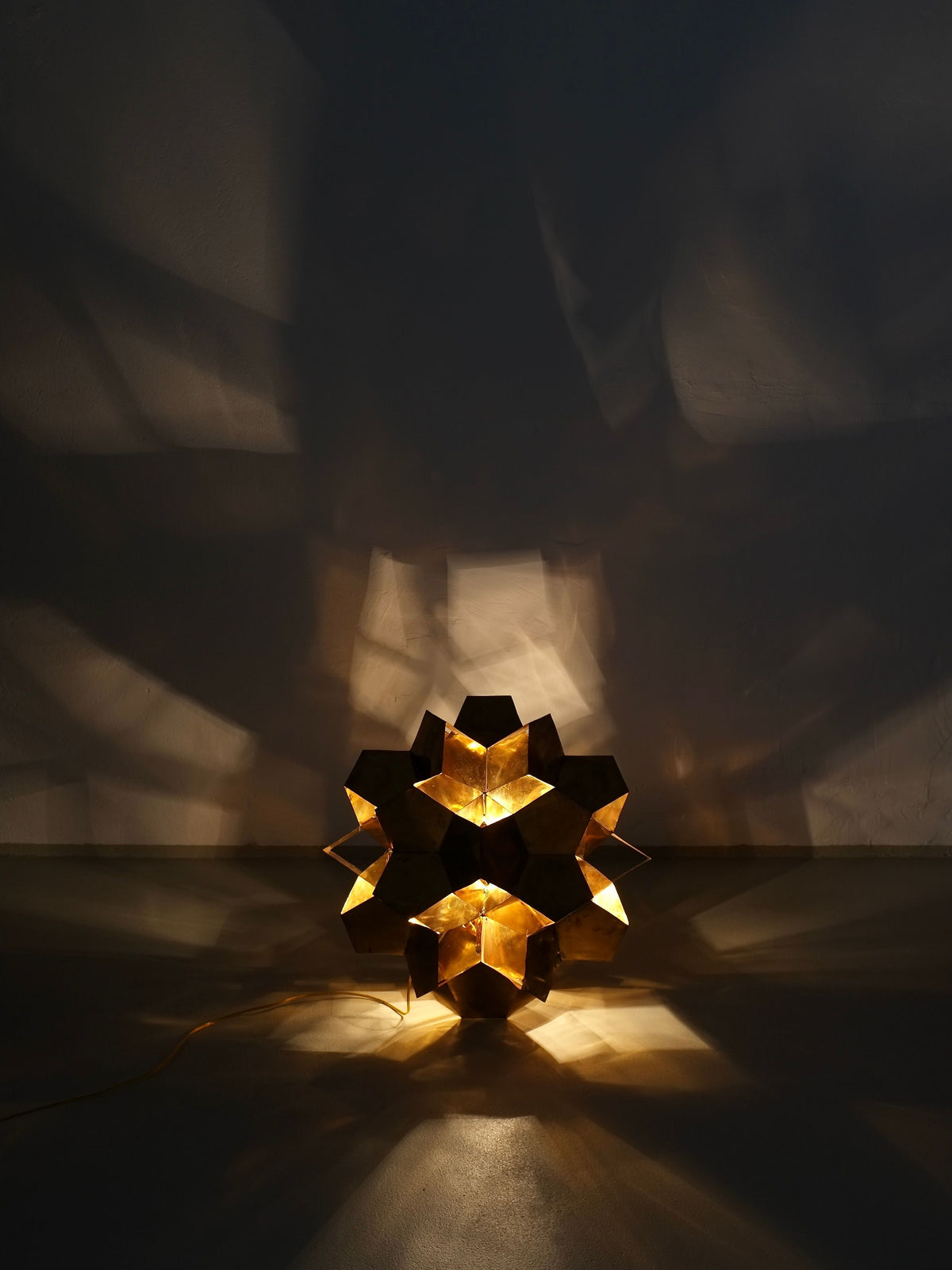 The Brutalist Brass Chandelier by Veter Vintage (Latvia, 70s) features a geometric, star-shaped design and emits warm light with E27 bulbs—casting bold angular shadows and serving as striking sculptural lighting for modern interiors.