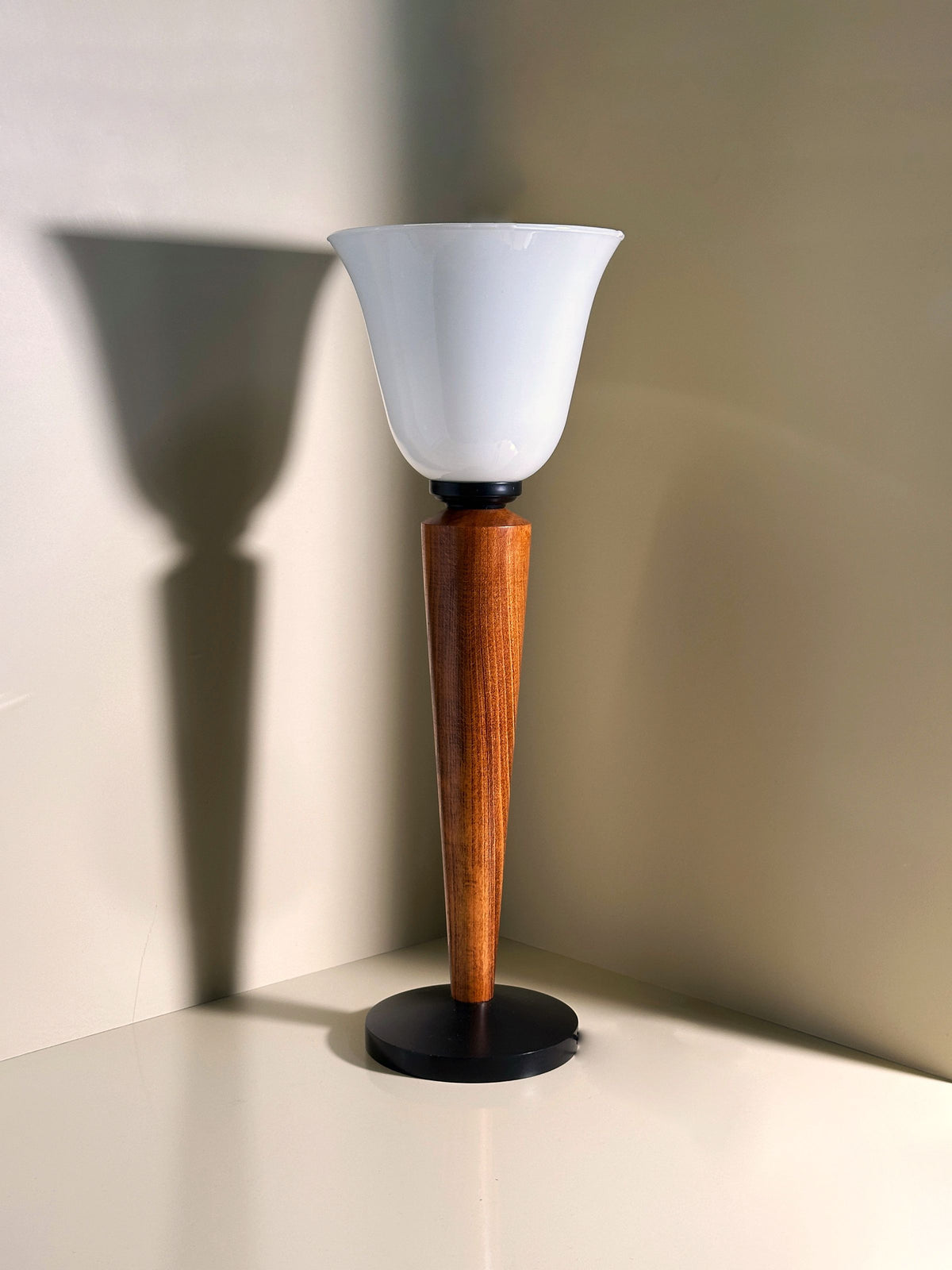 The Dodo Vintage Art Deco Chalice pairs feature frosted glass shades and teak wood stems on black circular bases, ideal for any corner by casting subtle shadows on light-colored walls.