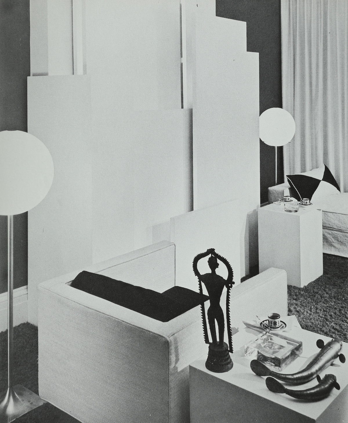 Modern white interior design setup with geometric furniture and decorative objects