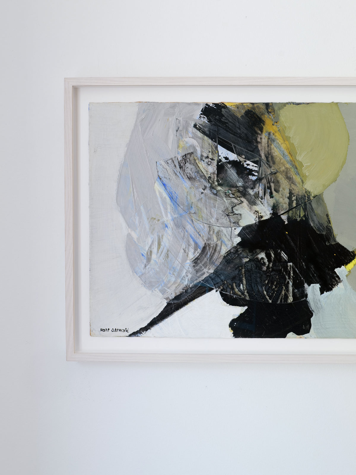 The "Abstract Composition" painting by Collection apart features dynamic brushstrokes in shades of grey, black, and muted yellow, evoking the style of a midcentury Hans Osswald piece. It is elegantly framed in light wood and showcased on a pristine white wall.