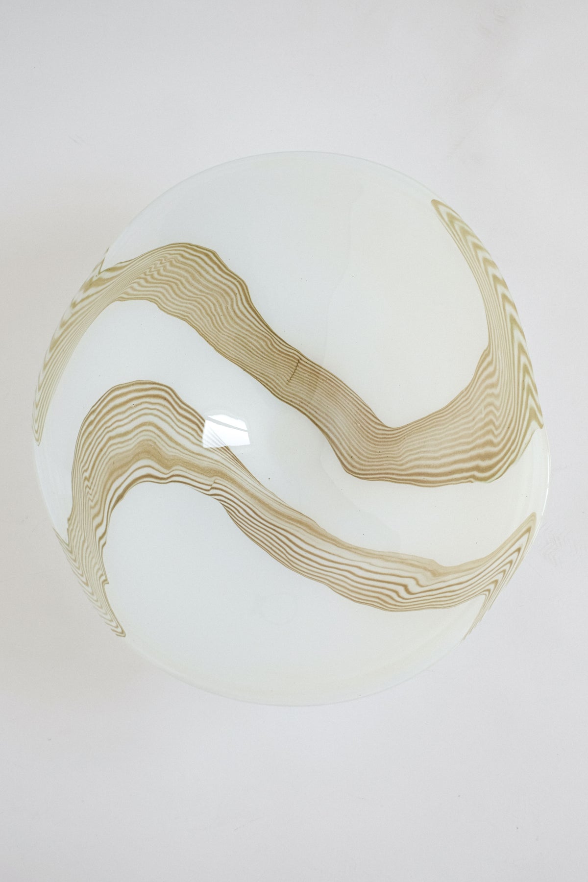 Large blown glass bowl with flowing amber ribbon pattern detail