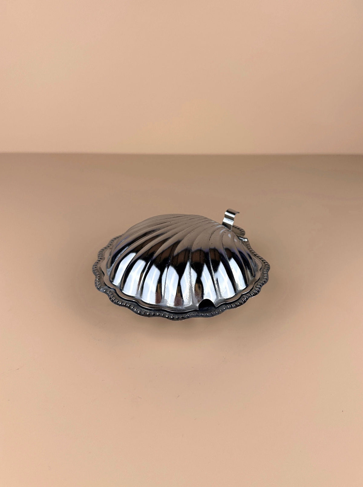  White porcelain butter dish in the shape of a seashell, with delicate patterns