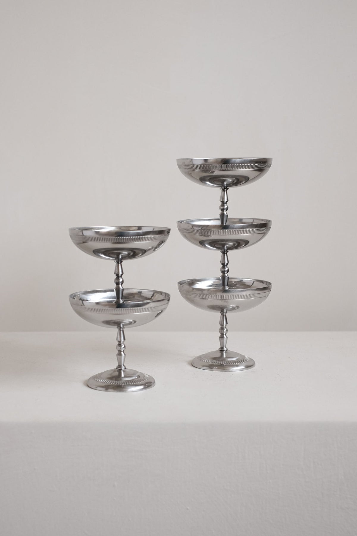 Two tiered silver metal ice coupes displaying elegant serving arrangement