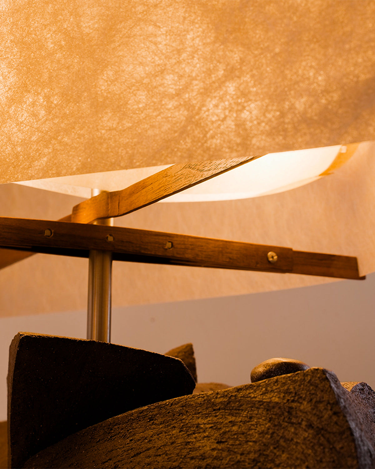 Close-up detail of Sunrise table lamp's warm wood frame and fabric shade