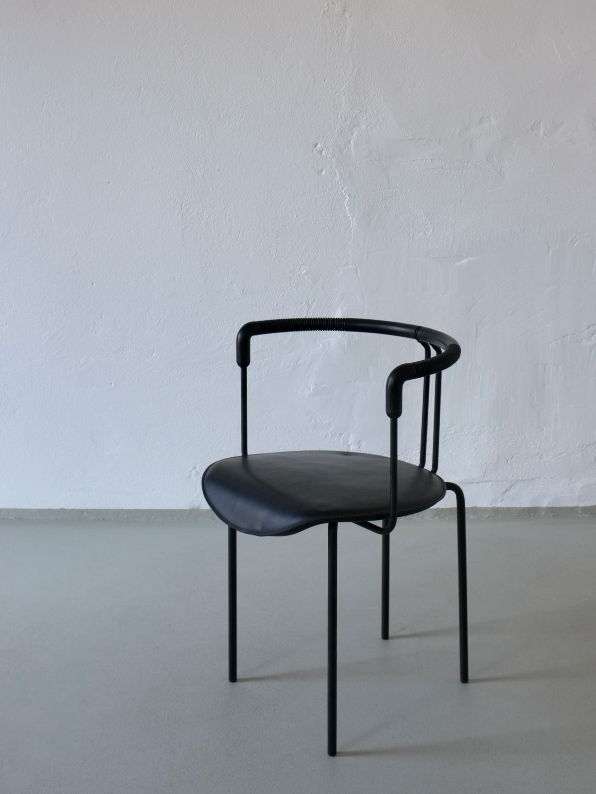 Postmodern black leather armchair with tubular steel frame detail