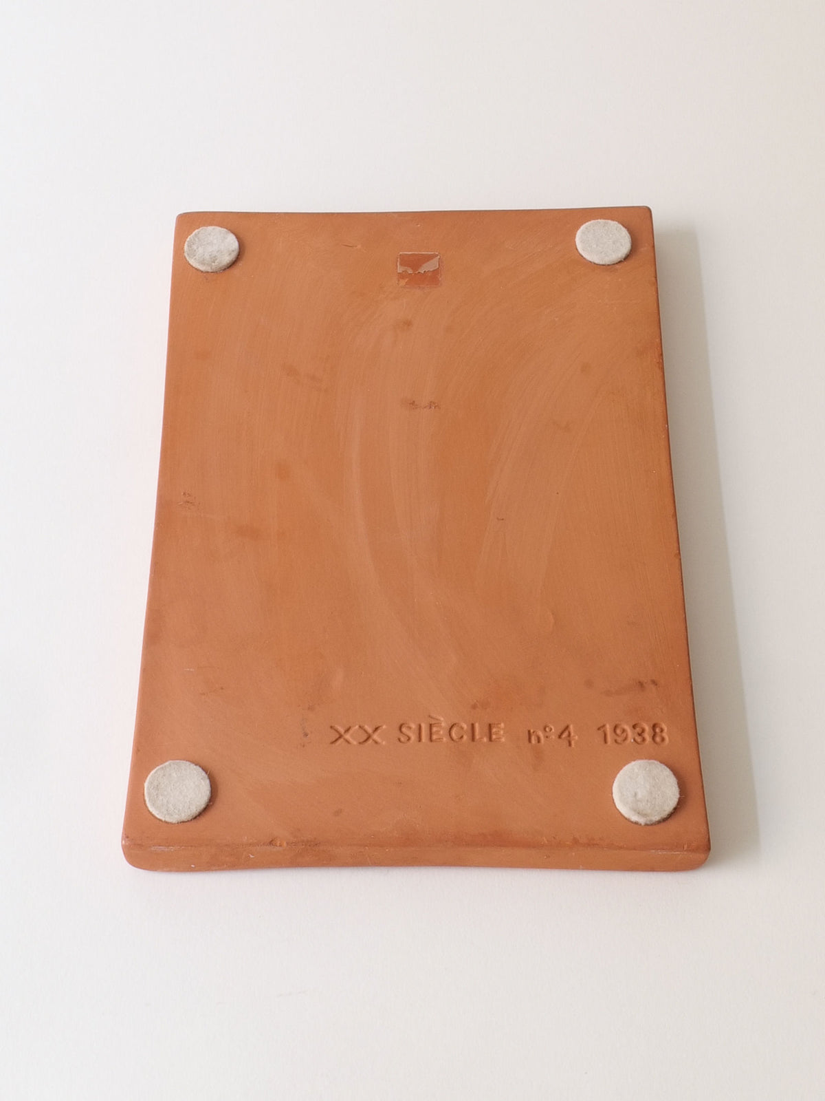 A rectangular ceramic tile with rounded corners and white pads features "XX SIECLE" and "4" from 1988. Reminiscent of a Catalan surrealist like Joan Miró, this piece evokes whimsy, as seen in the Terracotta Relief Plaque signed Joan Miró (1938) by Collection apart.