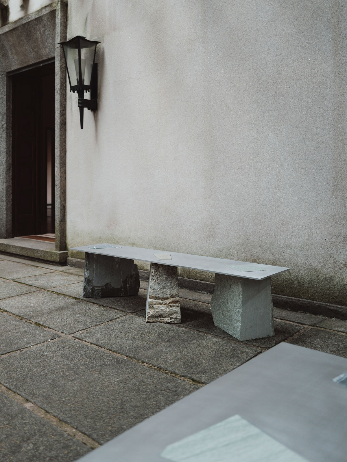 Fragments Milano stone bench outdoor setting against white wall