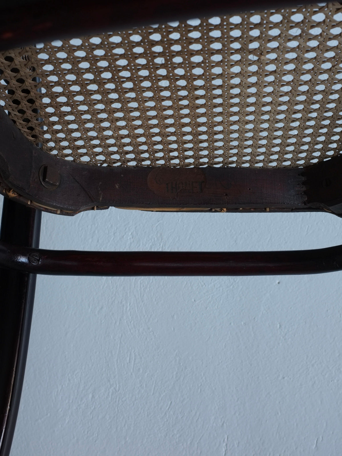 Close-up of woven cane seat detail on Thonet bentwood chair