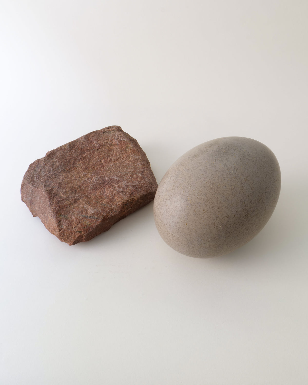 Brown rough stone and smooth grey ceramic egg sculpture by Vincent Nilsson