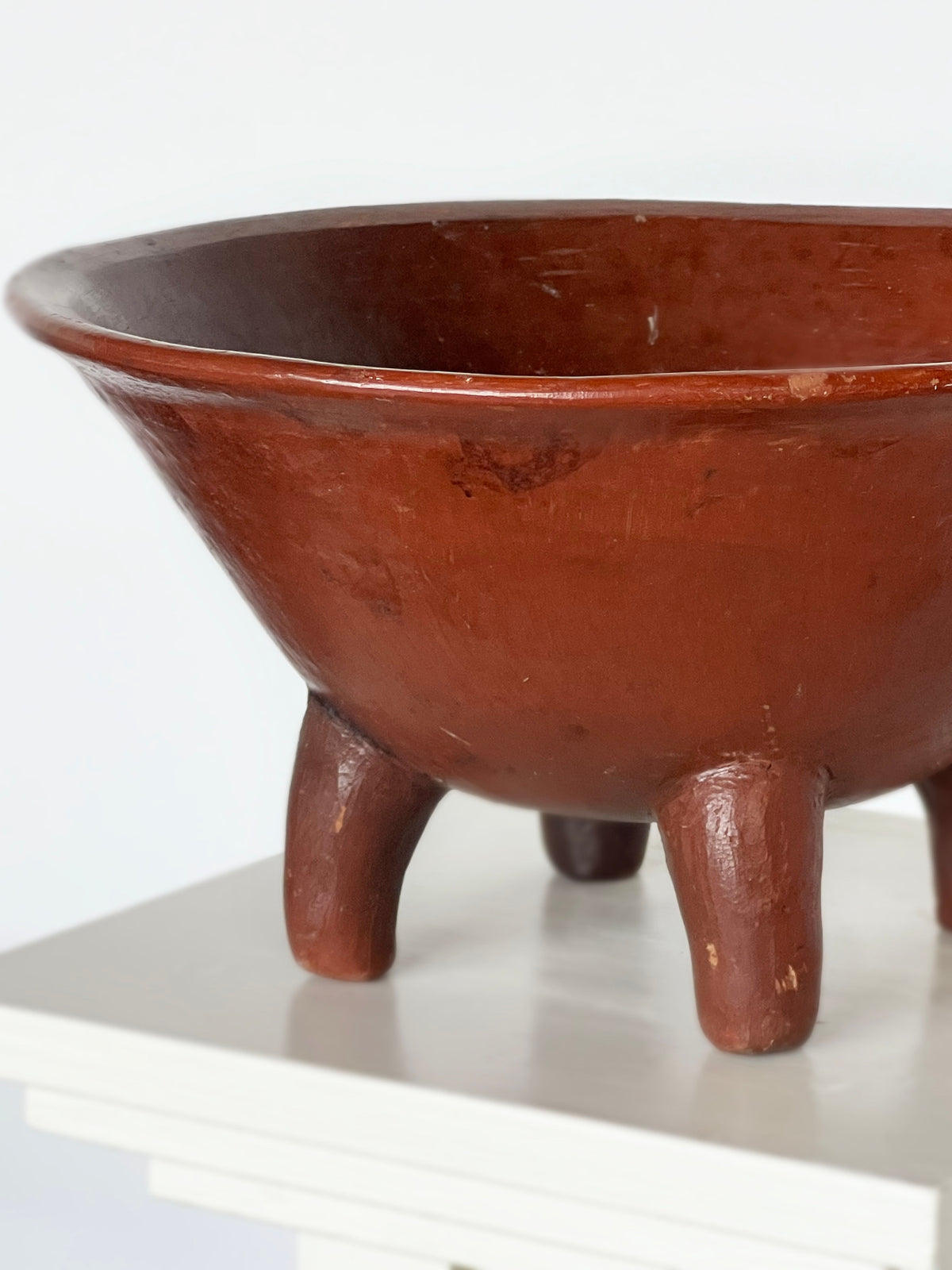 Handcrafted terracotta bowl with three legs, side profile view