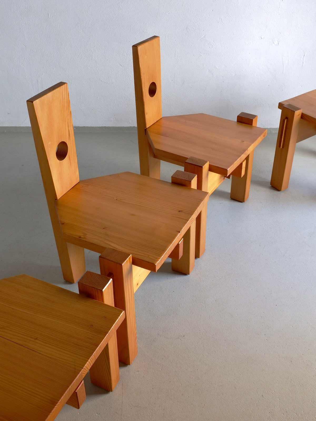 Four Sculptural Pine Chairs by Erwin Egel from the 1960s are arranged diagonally on a light-colored floor. Each chair boasts a high rectangular backrest with a circular cut-out and angular seats, reflecting the unique flair of Erwin Egel's design. Available at Veter Vintage.