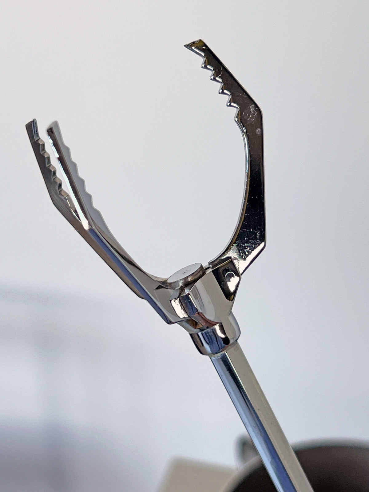 Close-up detail of chrome ice picker with serrated grip handle