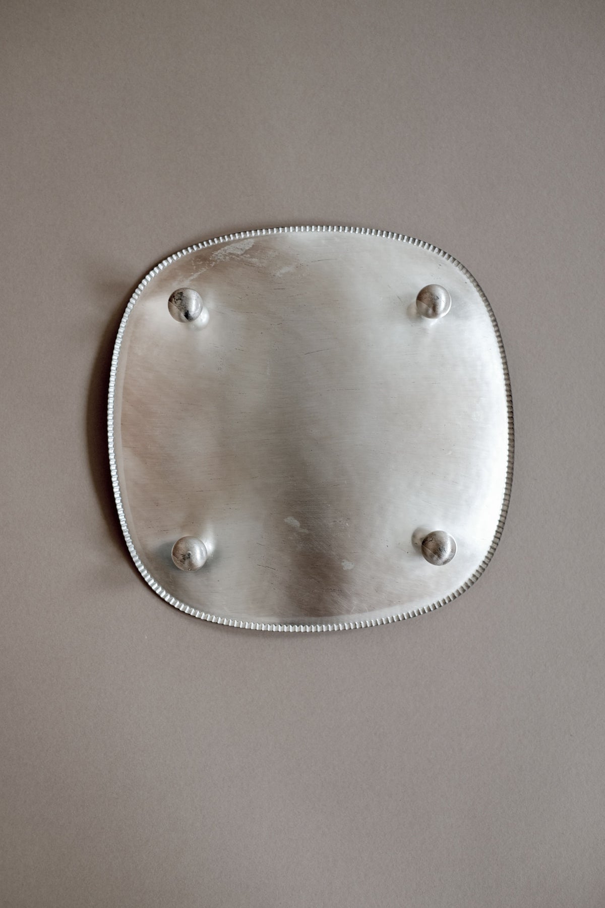 Silver-plated decorative dish bottom view with four mounting screws