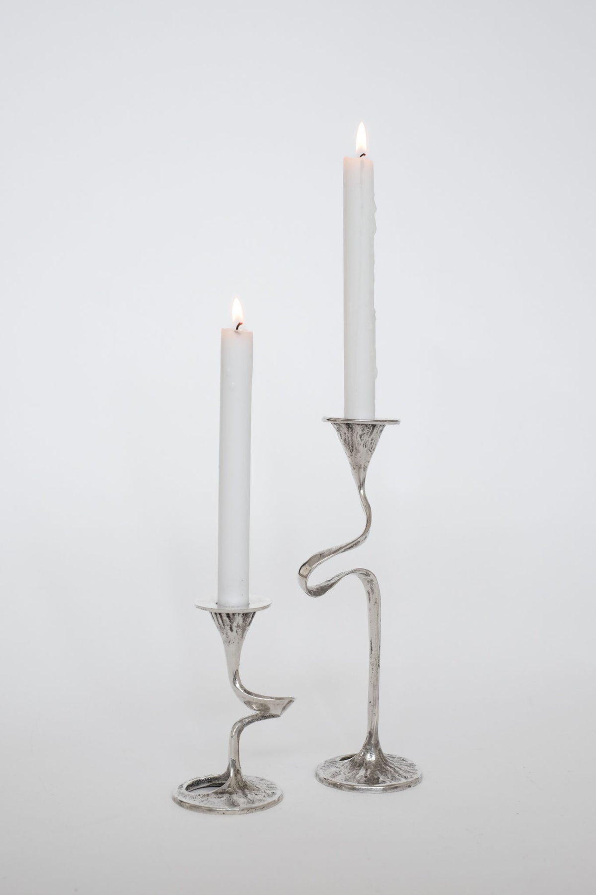 Vintage silver-plated twisted candle holders with lit white candles
