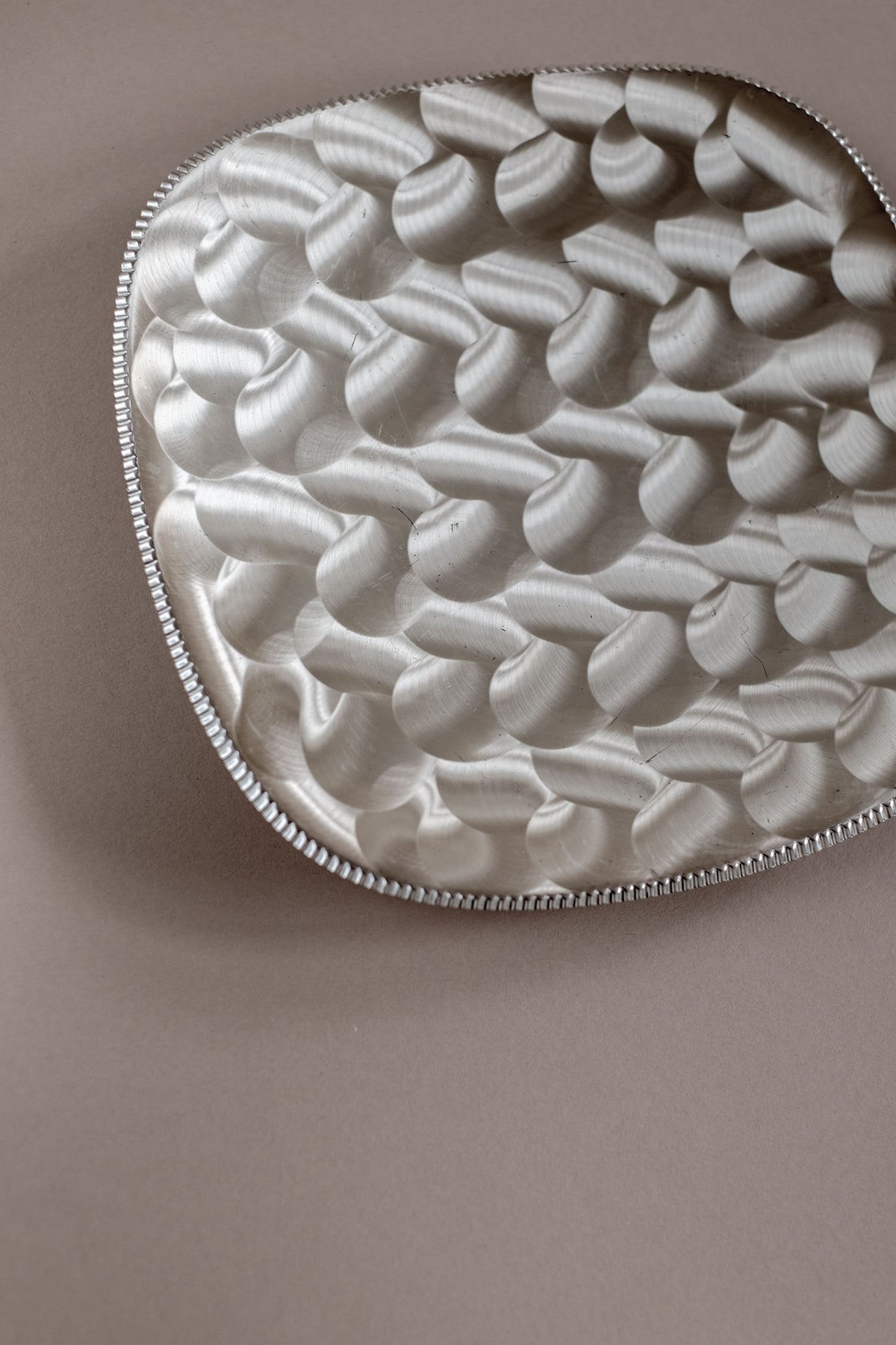 Silver-plated decorative dish with embossed curved pattern detail