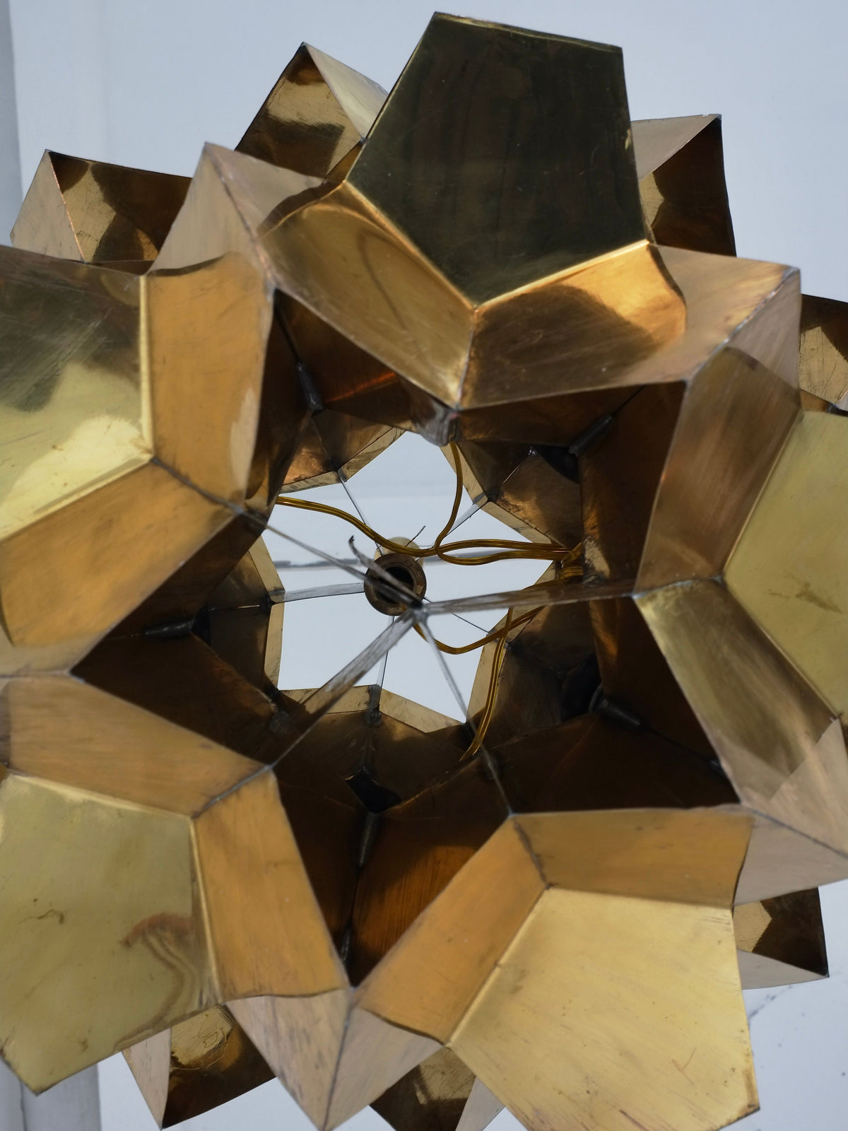 A close-up of the Veter Vintage Brutalist Brass Chandelier from Latvia, 70s, reveals its geometric, gold-toned solid brass and star-like sculptural design against a plain white backdrop.
