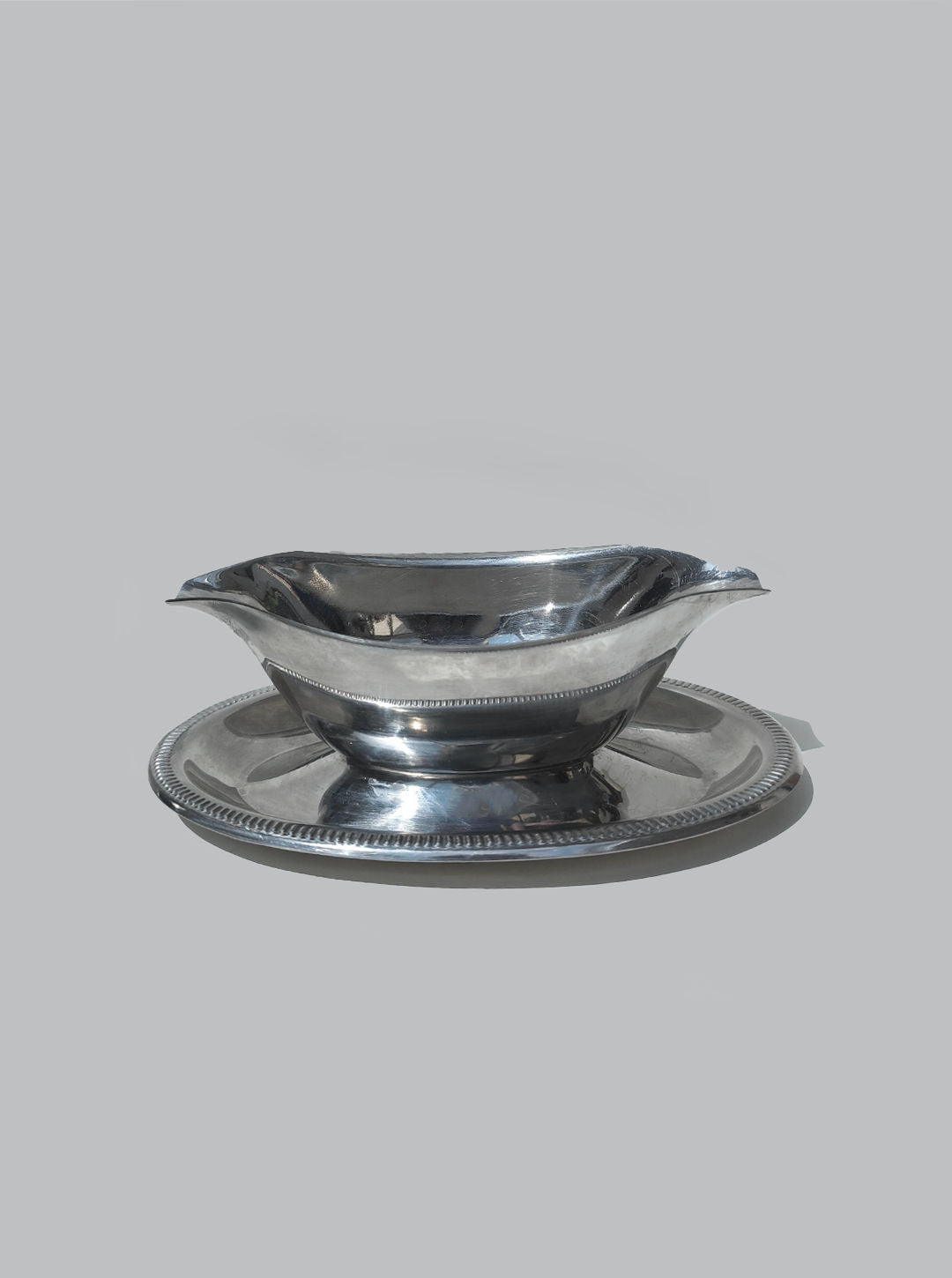 Polished steel gravy boat with matching saucer and rope edge detail