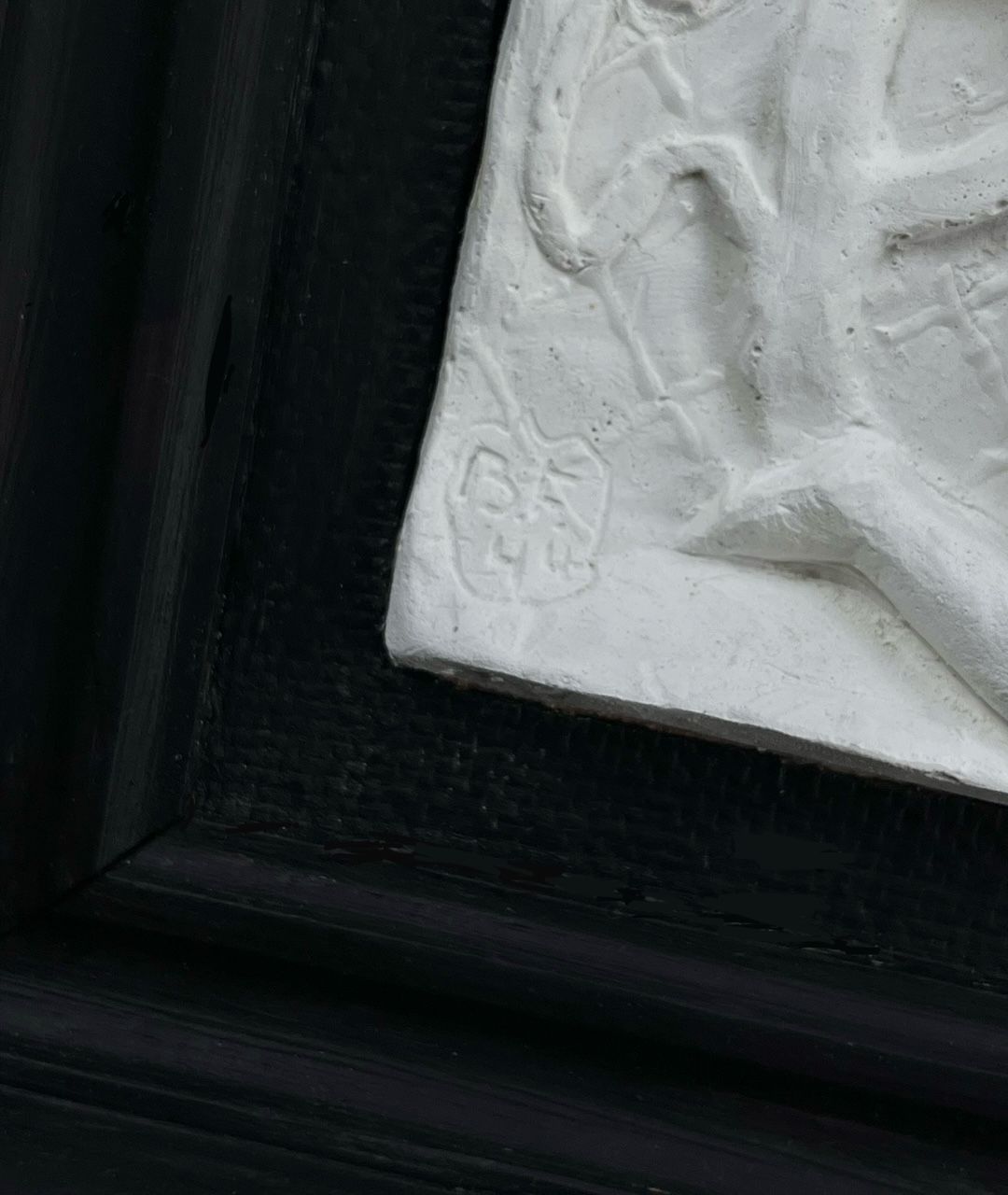 A detailed photo of a white embossed plaque showcases an abstract relief sculpture, signed "B.H." in the bottom left. It's framed darkly, reflecting Bo Fjaestad's intricate style. This midcentury plaster relief is from Médecine.