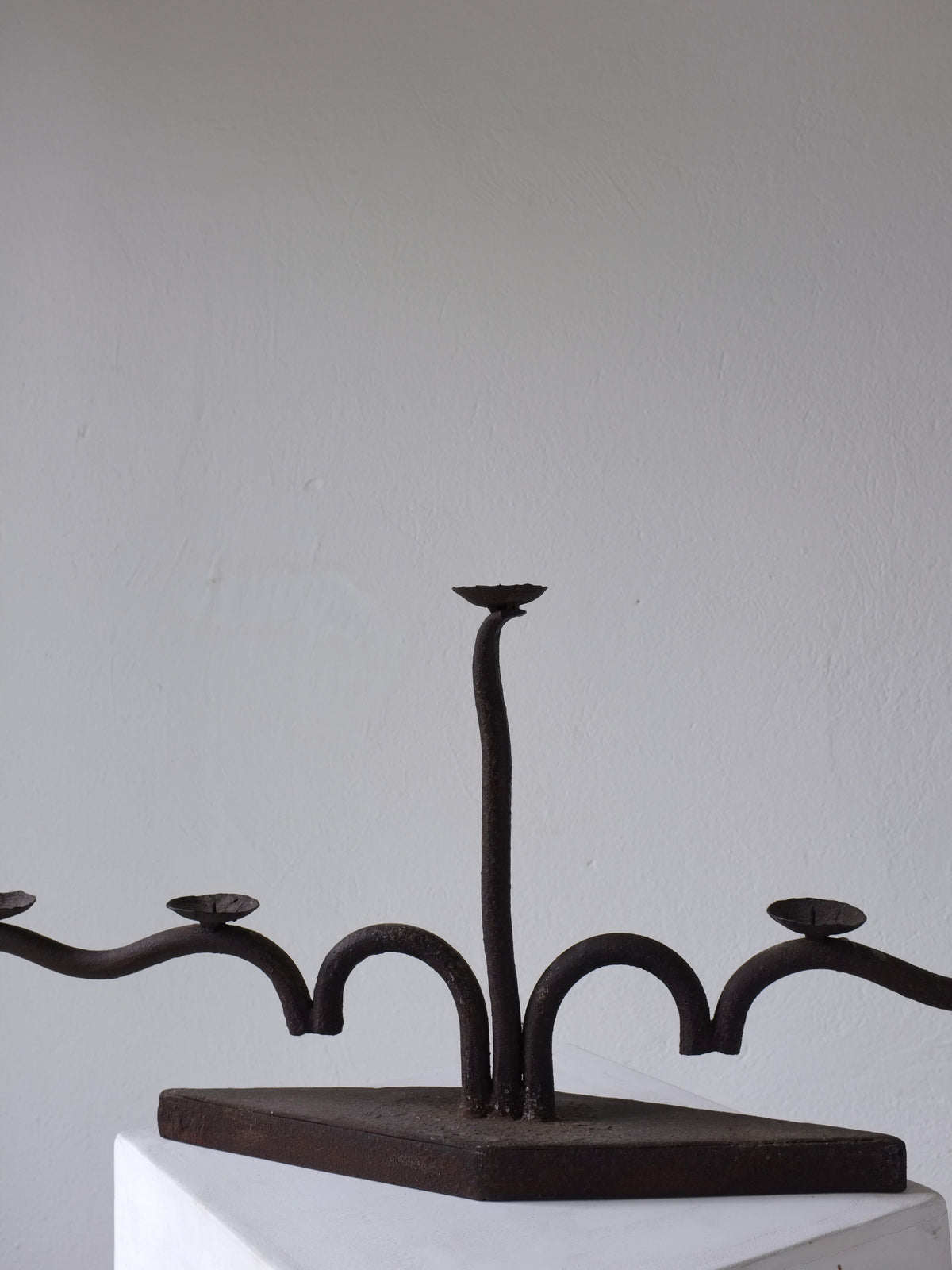 Large brutalist wrought iron candelabra profile view on white base