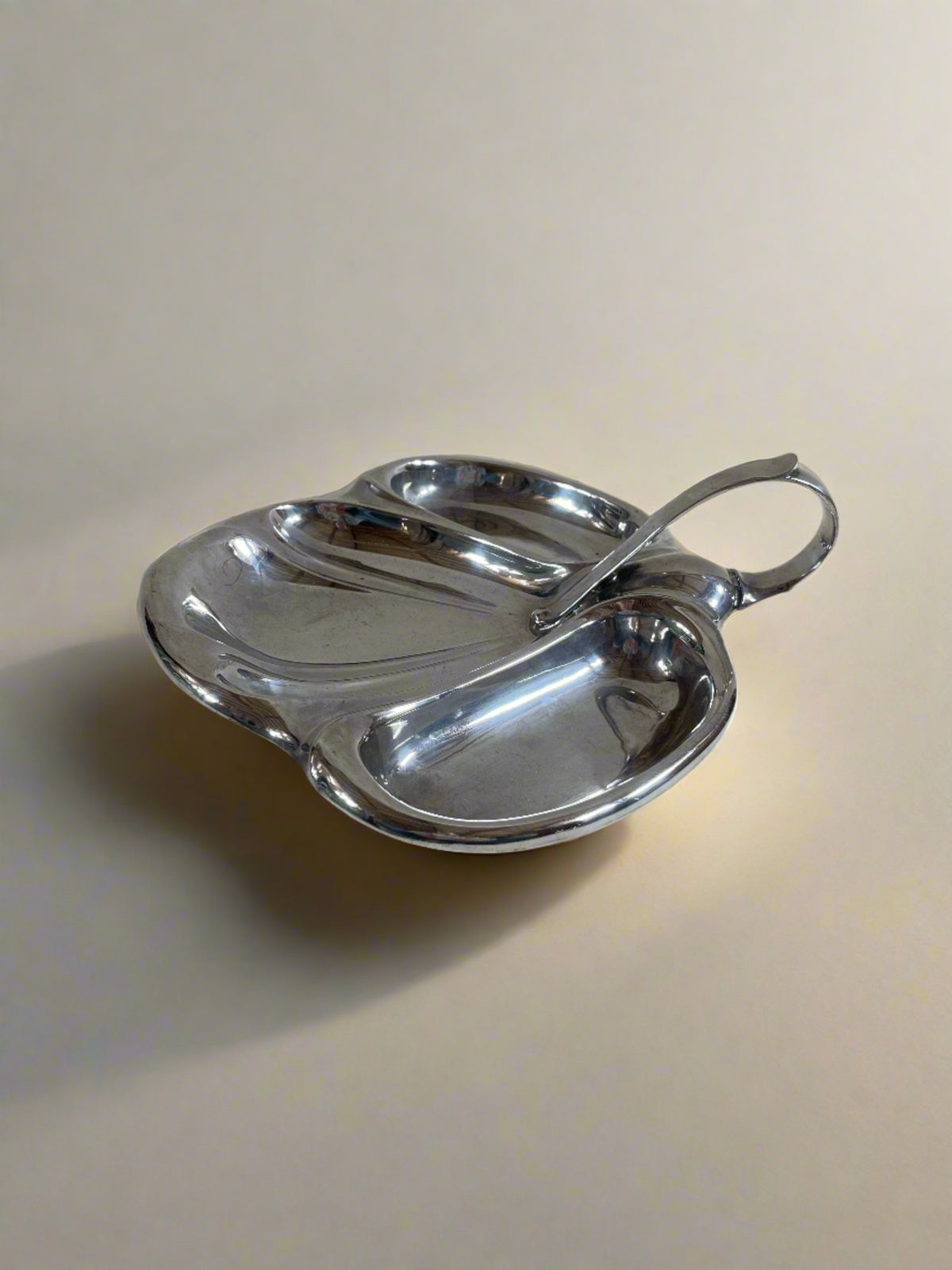 A Vintage Mappin and Webb Silver Plate Serving Dish by Maud Vaughan features three elongated oval compartments and a curved handle, set against a neutral background. Crafted by renowned British silversmiths, its elegant design marries functionality with timeless style.