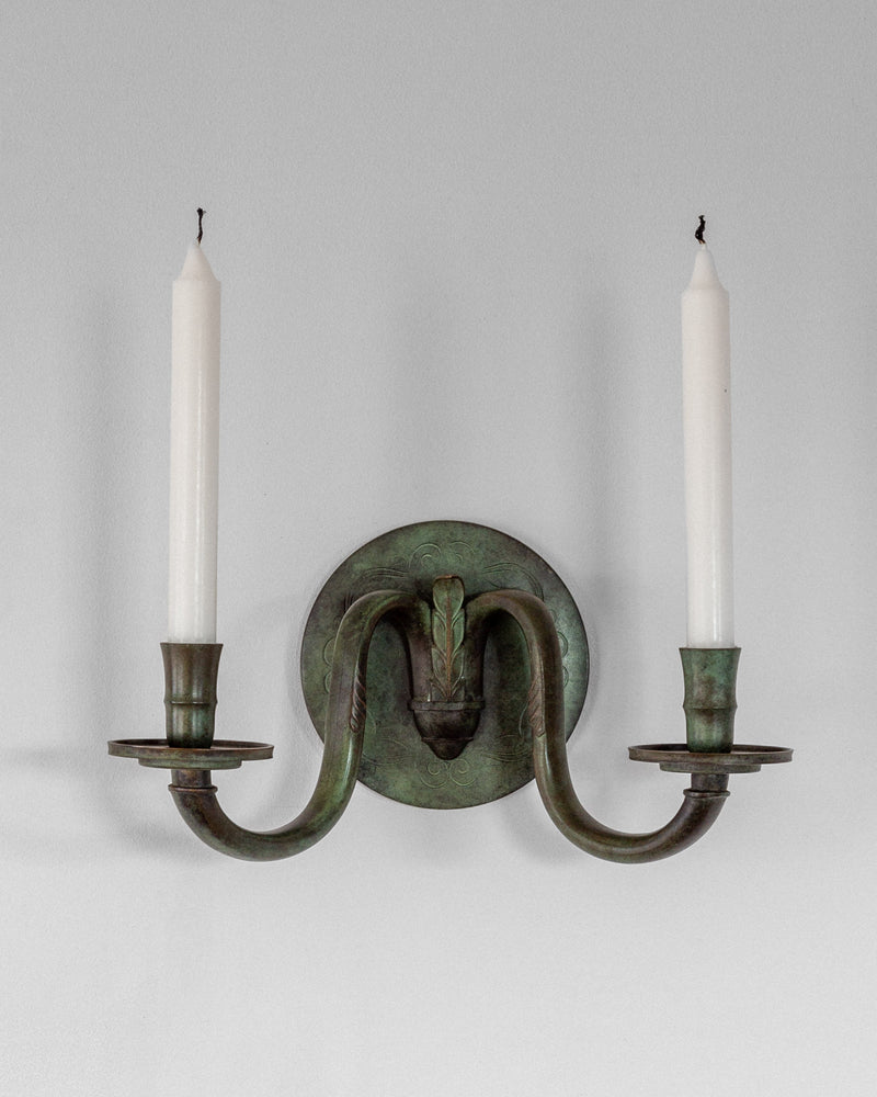 Art Deco bronze wall sconce with two candles and decorative backplate