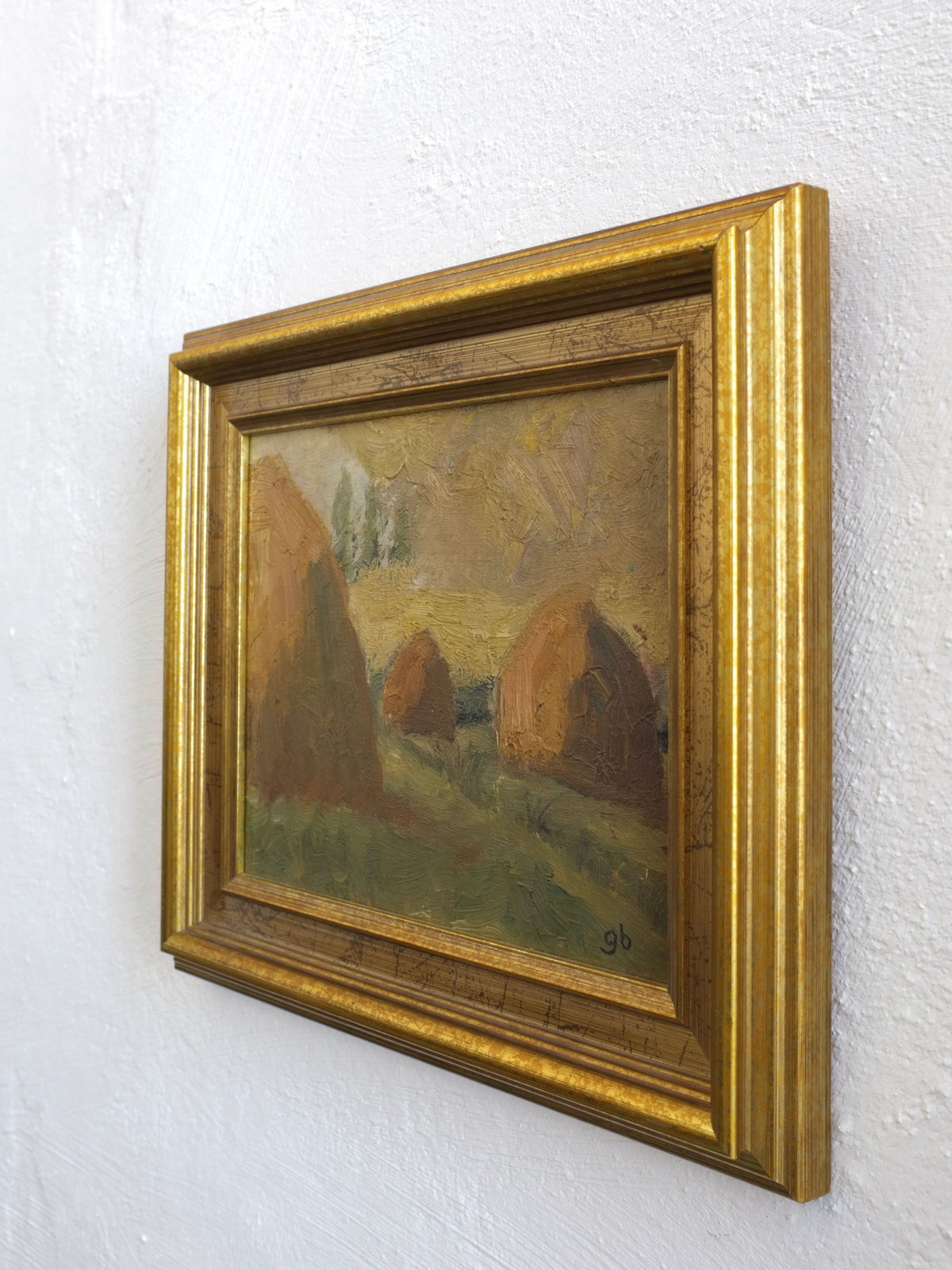 Framed 1950s landscape painting showing haystacks in golden frame