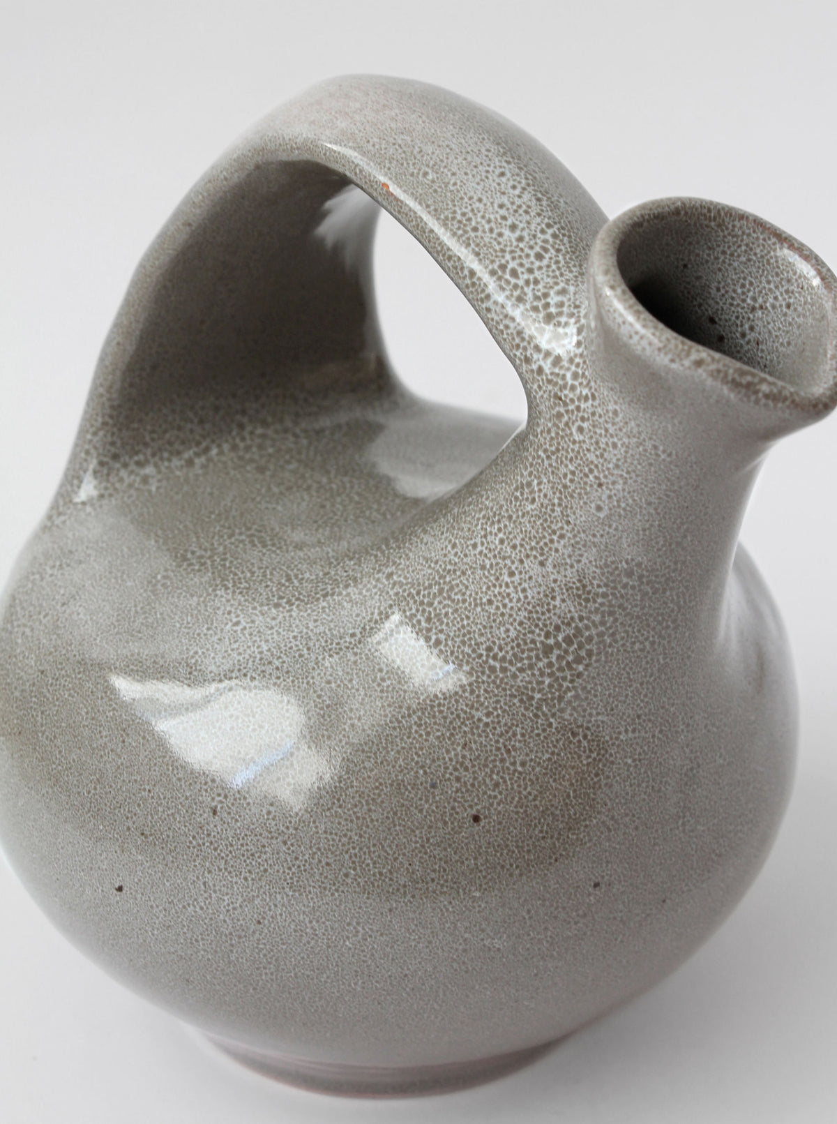 Close-up detail of grey ceramic jug with crackle glaze finish